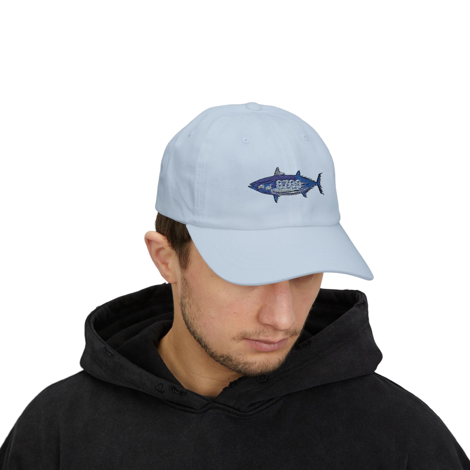 Model wearing a light blue cap with embroidered tuna fish – casual beachwear vibe